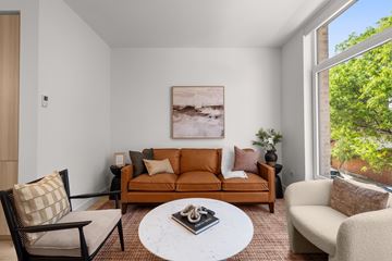 Chicago apartment for rent - A living room with a brown couch, a white coffee table, and a painting on the wall.