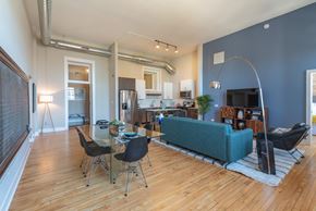 Chicago apartment for rent - A living room with a blue couch and a dining table with chairs.