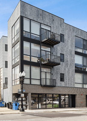 Chicago apartment for rent - A modern building with a black and white facade and a balcony on the second floor.