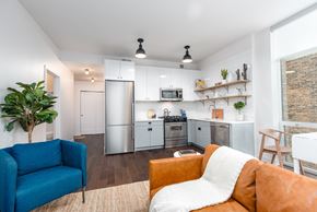 Chicago apartment for rent - A modern kitchen with a blue chair and orange couch.