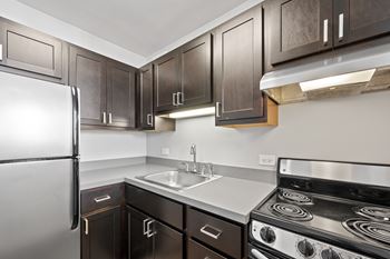 Kitchen with dark cabinetry and electric range