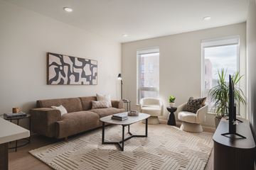 Lakewood apartment for rent - A living room with a brown couch, a coffee table, and a large painting on the wall.