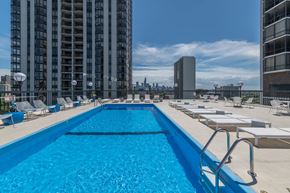 Chicago apartment for rent - a swimming pool on the rooftop of a building with a city in the background