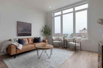 Cleveland apartment for rent - A living room with a brown leather sofa, a coffee table, and a painting on the wall.