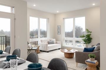 Rocky River townhouse for rent - A well-lit, modern living room with a dining table set for four.