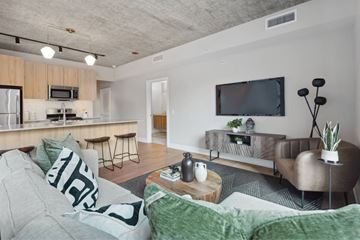 Chicago apartment for rent - A modern living room with a grey couch and a wooden coffee table.