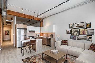 Chicago apartment for rent - A modern kitchen and living room with a white couch and a coffee table.