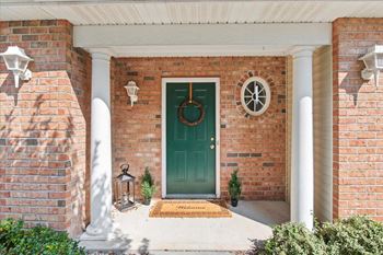 Private, covered front entrance with green door & welcome mat