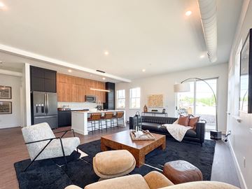 Pittsford apartment for rent - A modern living room with a black couch and a wooden coffee table.