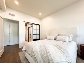Pittsford apartment for rent - A bedroom with a large bed and a sliding glass door.