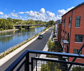 Pittsford apartment for rent - A car is driving down a street next to a river.
