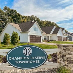 Victor townhouse for rent - Exterior of Champion Reserve Townhomes near the Gillis Road entrance. White townhomes with attached 2-car garages.