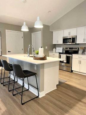 Victor townhouse for rent - Interior of Champion Reserve Townhome  with view of well equipped kitchen with stainless steel appliances, quartz countertops, and breakfast bar/kitchen island.