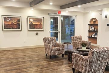 Phoenix apartment for rent - a living room with chairs and a coffee table and paintings on the wall