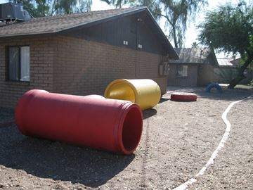 Phoenix apartment for rent - a playground with red and yellow barrels in front of a house