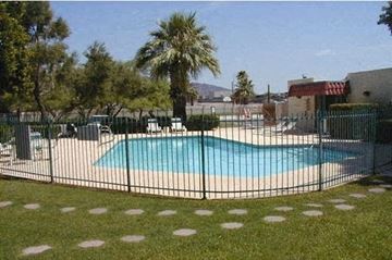 Phoenix apartment for rent - a swimming pool is behind a wrought iron fence