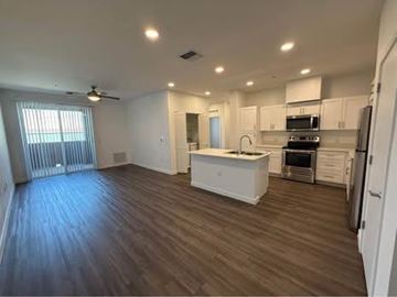Phoenix apartment for rent - A spacious kitchen with white cabinets and a wooden floor.