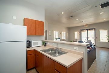Peoria apartment for rent - A kitchen with a white refrigerator and wooden cabinets.