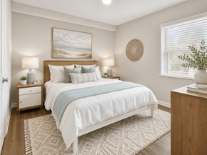 Raleigh apartment for rent - A bedroom with a large bed and a painting on the wall.