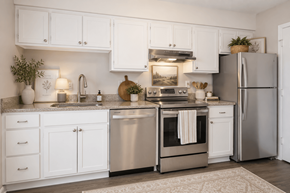 Raleigh townhouse for rent - A modern kitchen with white cabinets and stainless steel appliances.