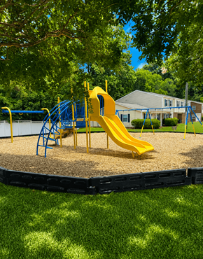 Raleigh townhouse for rent - A playground with a yellow slide and blue play structure.