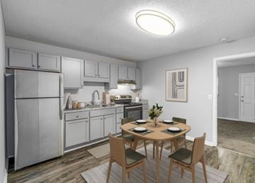 Gastonia apartment for rent - A kitchen with a table and chairs in front of it.