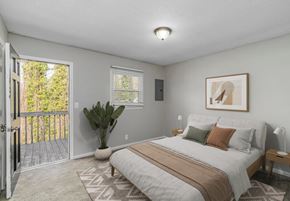 Gastonia apartment for rent - A bedroom with a bed, a potted plant, and a painting on the wall.