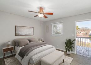Gastonia apartment for rent - A bedroom with a bed, a bench, a ceiling fan, and a window with blinds.
