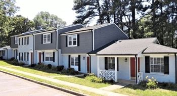 A white house with a red door and black shutters at greenwood village