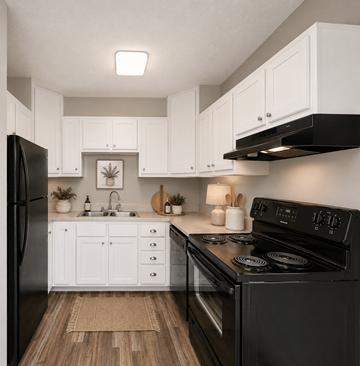 Charlotte apartment for rent - A black stove in a kitchen with white cabinets.