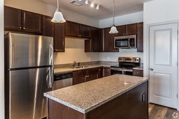 A kitchen with an island and stainless steel appliances