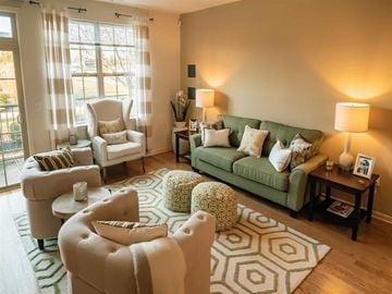 Hillsborough apartment for rent - A living room with a green couch and a white chair.