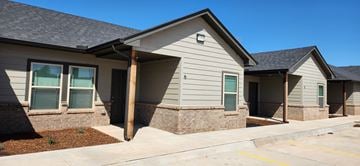 Oklahoma City apartment for rent - A small building with a grey roof and a yellow line in front.