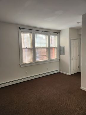 Lancaster apartment for rent - A room with brown carpet and a window with blinds.