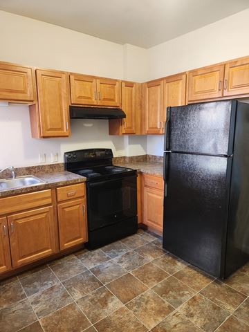 Lancaster apartment for rent - A kitchen with black appliances and wooden cabinets.