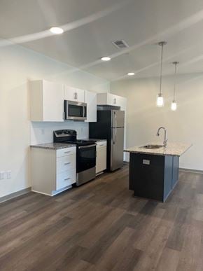 Shepherdsville townhouse for rent - A kitchen with a black fridge and white cabinets.