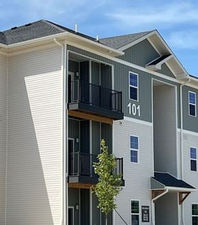 Shepherdsville townhouse for rent - Apartment building with balconies and a tree in front.