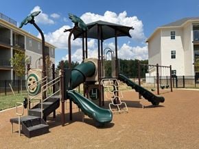Shepherdsville townhouse for rent - A playground with a green slide and a black metal structure.