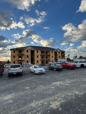 Shepherdsville townhouse for rent - A parking lot with cars and a building in the background.