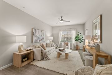 San Antonio apartment for rent - A living room with a white sofa, a wooden coffee table, and a large painting on the wall.