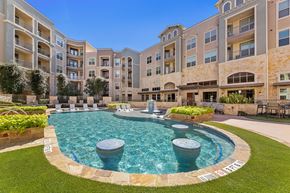 San Antonio apartment for rent - A large swimming pool surrounded by a stone border in a courtyard.