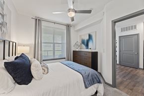 Cedar Hill apartment for rent - A bedroom with a bed, dresser, and a ceiling fan at The Preserve at Preston Trails Apartments, Cedar Hill, TX