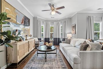Ladson apartment for rent - A living room with a large painting on the wall and a ceiling fan.