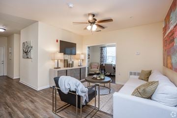 Macon apartment for rent - A living room with a white couch and a black chair.