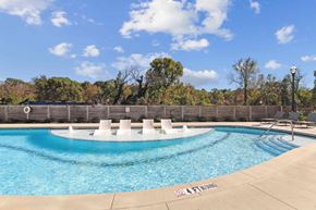 Mableton townhouse for rent - A pool with a fence and trees in the background.