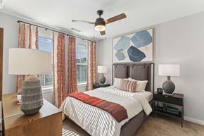 Mableton townhouse for rent - A bedroom with a bed, nightstands, and a ceiling fan.