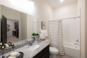 A bathroom with a white shower curtain and a white toilet
