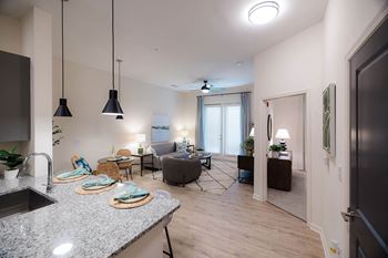 A modern kitchen with granite countertops and pendant lights