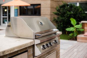 A stainless steel grill is on a patio