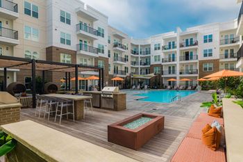 A large outdoor pool area with a hot tub and lounge chairs